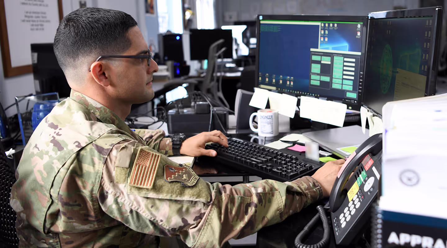 U.S. Air Force computer systems programming specialists working at their terminals.